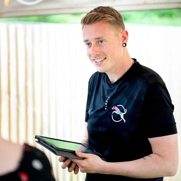 Photo of Zak (our trainer at Wakefield) holding an iPad during an assessment with a new customer.